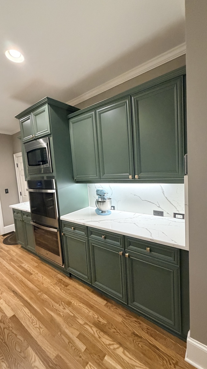 Real finished cabinets in Rosemary green around a double oven, a Cabinet Painting Guys client job