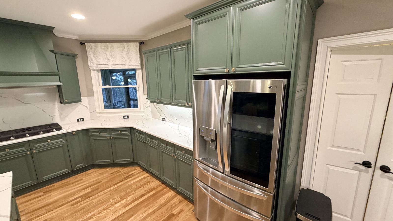 Real finished kitchen, Rosemary green cabinets around a stainless fridge, a Cabinet Painting Guys client job