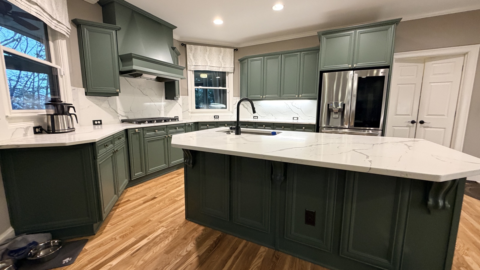 Real finished kitchen island with Rosemary green cabinets and sink, a Cabinet Painting Guys client job